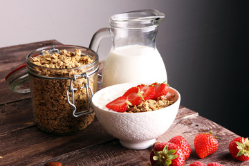 Healthy breakfast concept with oat flakes and fresh berries on rustic background. Food made of granola and musli. Healthy muesli with strawberries, nuts and milk.