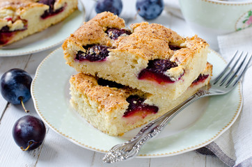 Plum cake with caramel on a white wooden table