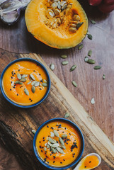 Homemade vegetable soup with pumpkin with cream and black sesame, top view with copy space