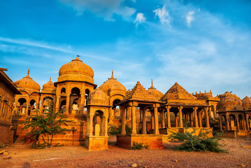 The royal cenotaphs of historic rulers, also known as Jaisalmer Chhatris, at Bada Bagh in Jaisalmer, Rajasthan, India. Cenotaphs made of yellow sandstone at sunset