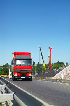 The Truck Carries Cargo On The Highway In The Tilt Van. Front View. Wide Angle. Vertical Frame