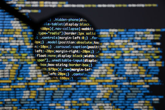 Real css code developing screen. Programing workflow abstract algorithm concept. Lines of css code visible under magnifying lens.