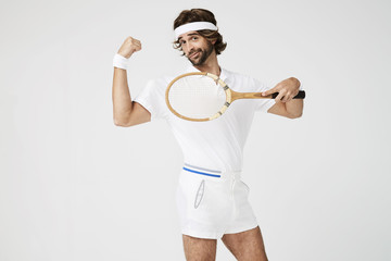 Funny tennis dude flexing muscle with racket, portrait