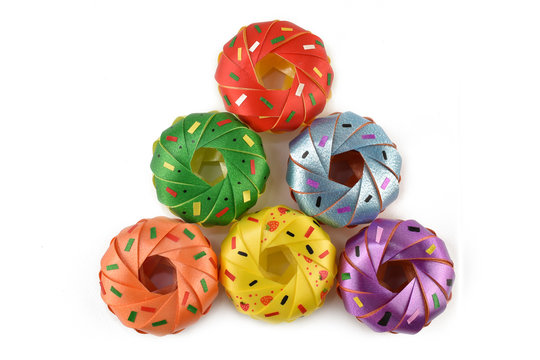 Coin folding with Ribbon is shaped a colorful Donut isolated on white background for ordination scatter ceremony of buddhism./ Donut is a type of fry dough confectionery  or dessert food.