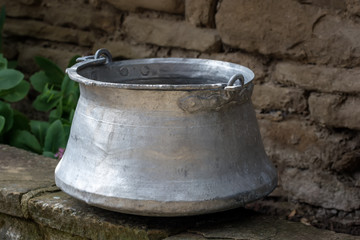 Fototapeta premium Old metal water container in the garden- traditional Bulgarian copper water container (bakir). Used to bring water from the well.