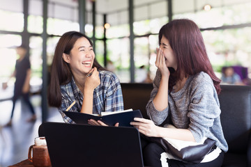 Two asian woman talking and discussion about work at coffee shop. Two asian teenage student college feeling funny and happy lifestyle.