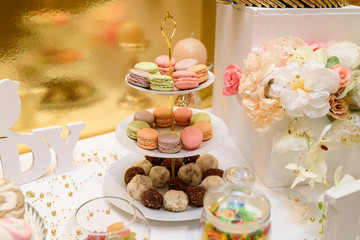 French colorful macaroons on cake stand. Birthday party. Holiday candy bar, free space. Table with sweets. Catering in the restaurant