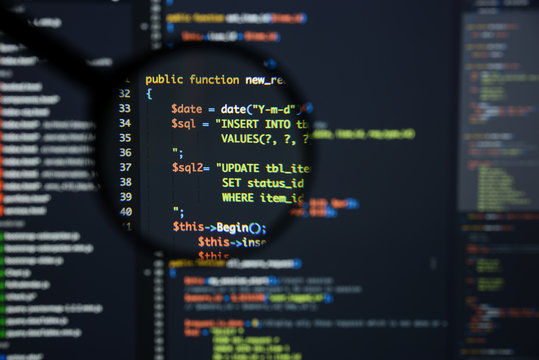 Real Php code developing screen. Programing workflow abstract algorithm concept. Lines of Php code visible under magnifying lens.