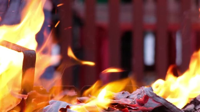 Man stir ash and coul by iron poker in fire