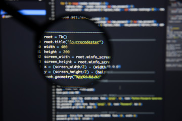 Real Python code developing screen. Programing workflow abstract algorithm concept. Lines of Python code visible under magnifying lens.