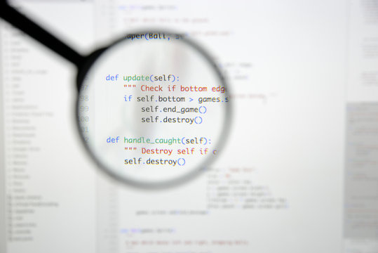 Real Python code developing screen. Programing workflow abstract algorithm concept. Lines of Python code visible under magnifying lens.