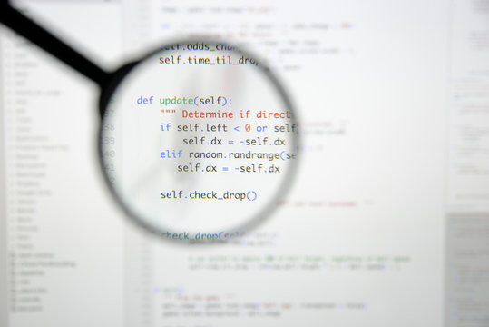 Real Python code developing screen. Programing workflow abstract algorithm concept. Lines of Python code visible under magnifying lens.