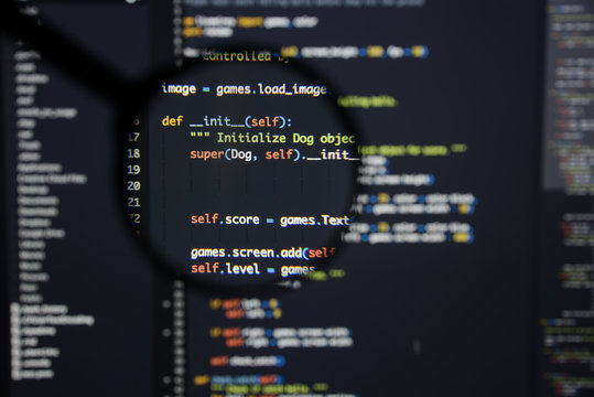 Real Python code developing screen. Programing workflow abstract algorithm concept. Lines of Python code visible under magnifying lens.
