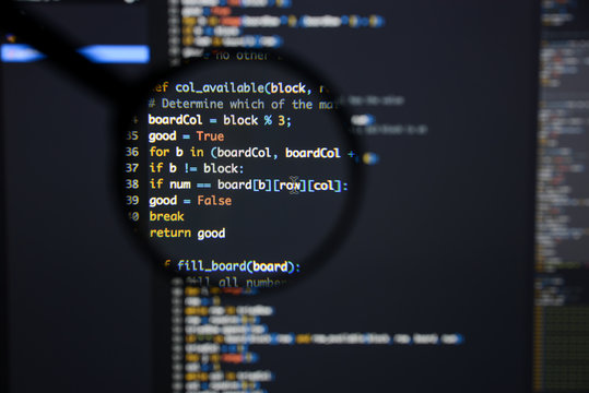 Real Python code developing screen. Programing workflow abstract algorithm concept. Lines of Python code visible under magnifying lens.