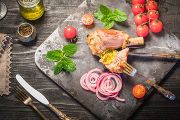 Lamb shank dinner, with vegetables, parsley, mint jam and red wine on black rustic wooden table, top view, copy space