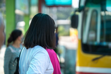 Young girl waiting for bus at bus station. Closeup.