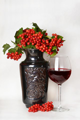 A glass of wine and viburnum berries.