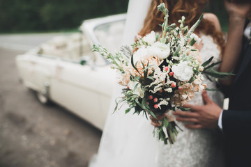 Luxury wedding bouquet in bride's and groom hands