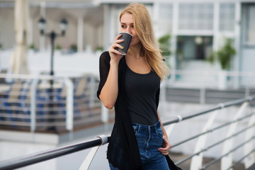 Girl with cup of hot drink on the white terrace near the ocean