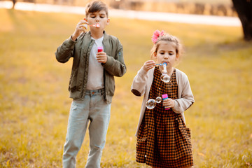 Fototapeta premium Siblings blowing soap bubbles