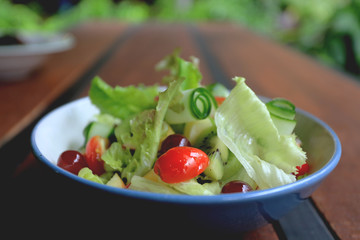 Bowl of healthy fresh fruit salad on wooden table, Delicious salad with mix fruit and vegetable,...