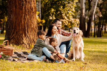 Family on picnic petting dog