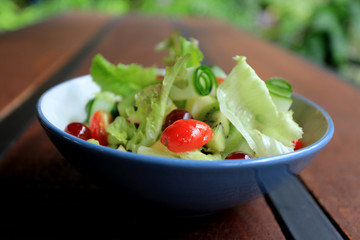 Bowl of healthy fresh fruit salad on wooden table, Delicious salad with mix fruit and vegetable, organic salad for healthy 