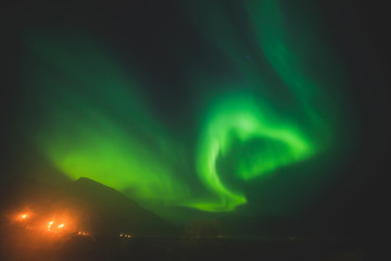 Beautiful picture of massive multicolored green vibrant Aurora Borealis, Aurora Polaris, also know as Northern Lights in the night sky over Norway, Scandinavia