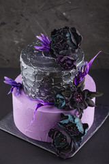 Artwork wedding cake with fake flowers on black background