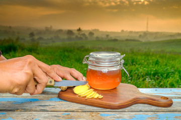 Alternative Medicine with garlic and  honey on wooden table. Beautiful sunrise as background.