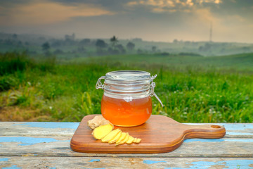 Alternative Medicine with garlic and  honey on wooden table. Beautiful sunrise as background.
