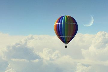 Aerostat floating in day sky. Mixed media