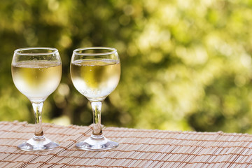 Glasses of wine on a bright green background of nature.