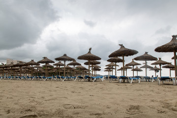 Leere Liegen am Strand an einem regnerischen Tag