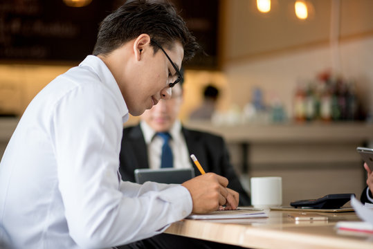 Business man working with documents and writing something idea on blank notebook in cafe