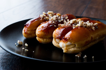 Caramel Eclairs with Hazelnut and cream in black plate.