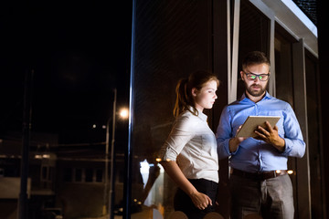 Businesspeople in the office at night working late.