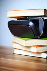 VR glasses and books on a table symbolizing digital learning