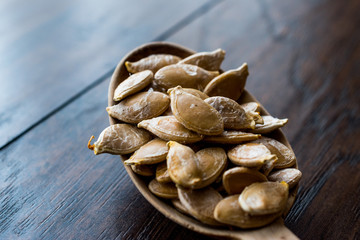 Pumpkin seeds in wooden spoon.