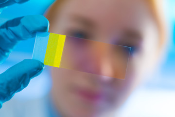 scientist woman holding microscope slide