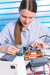 Young woman fix PC component in service center