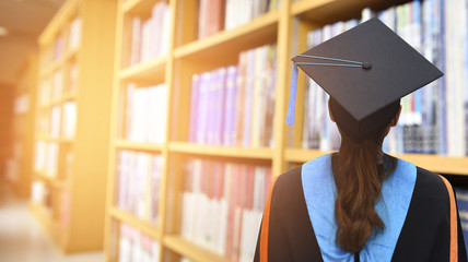Graduates stand in the library of the College.
