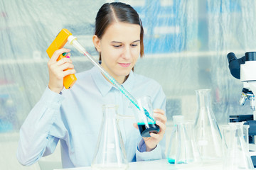 Woman Scientist Adding Liquid To Test Tube With Pipette In Lab