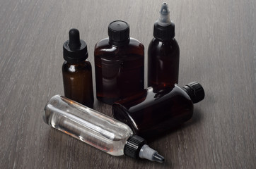 vaping e-cigarette liquid on wooden background