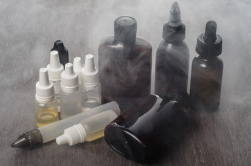 vaping e-cigarette liquid on wooden background