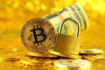 Physical version of Bitcoin (new virtual money) and golden padlock. Conceptual image for money and...