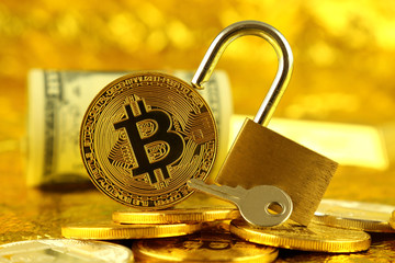 Physical version of Bitcoin (new virtual money) and golden padlock. Conceptual image for money and...