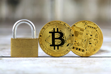 Physical version of Bitcoin (new virtual money) and golden padlock. Conceptual image for money and...