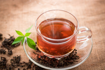 glass of hot tea on hemp sack and table in morning.