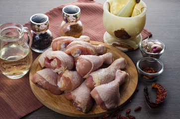 Fresh raw chicken legs arrangement on kitchen cutting board